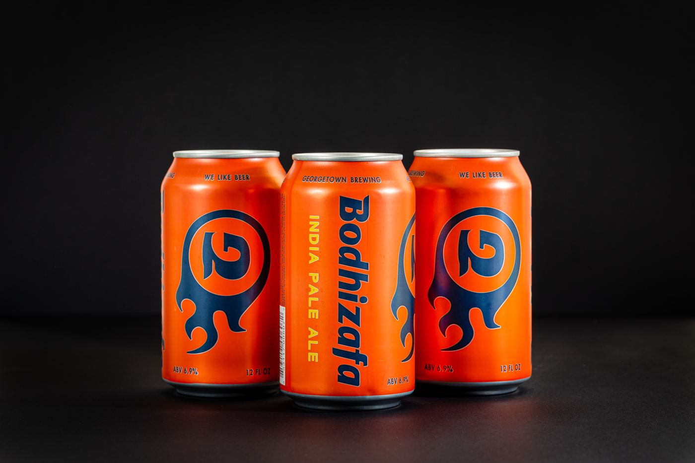 Three orange Bodhizafa IPA cans on black