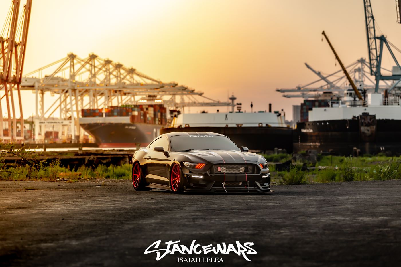 Black Mustang GT350 with red forged wheels at the Port of Seattle cranes